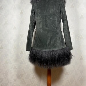 May include: A dark gray suede jacket with a black faux fur collar and trim. The jacket has a long, fitted silhouette and a button closure.