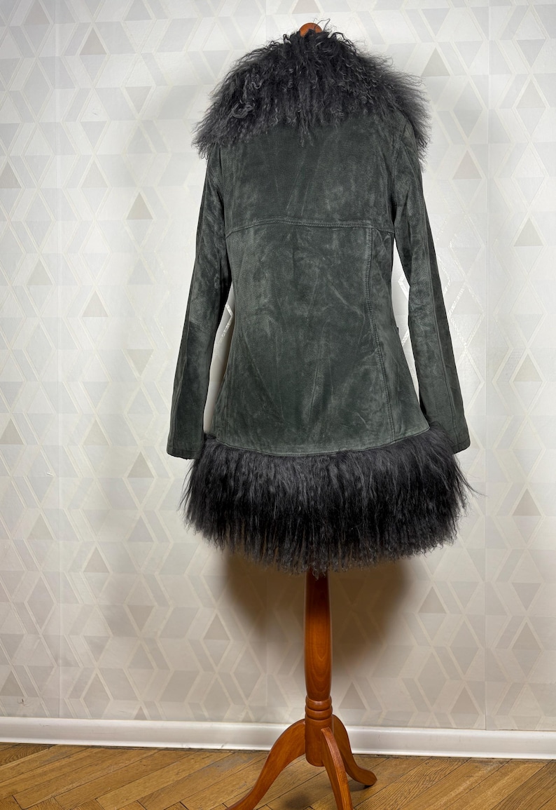 May include: A dark gray suede jacket with a black faux fur collar and trim. The jacket has a long, fitted silhouette and a button closure.