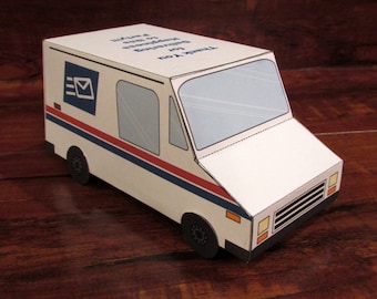 May include: A white cardboard model of a mail truck with blue and red stripes. The truck has a mail logo on the side and the text "Thank you for Delivering Happiness & Smiles" on the top.