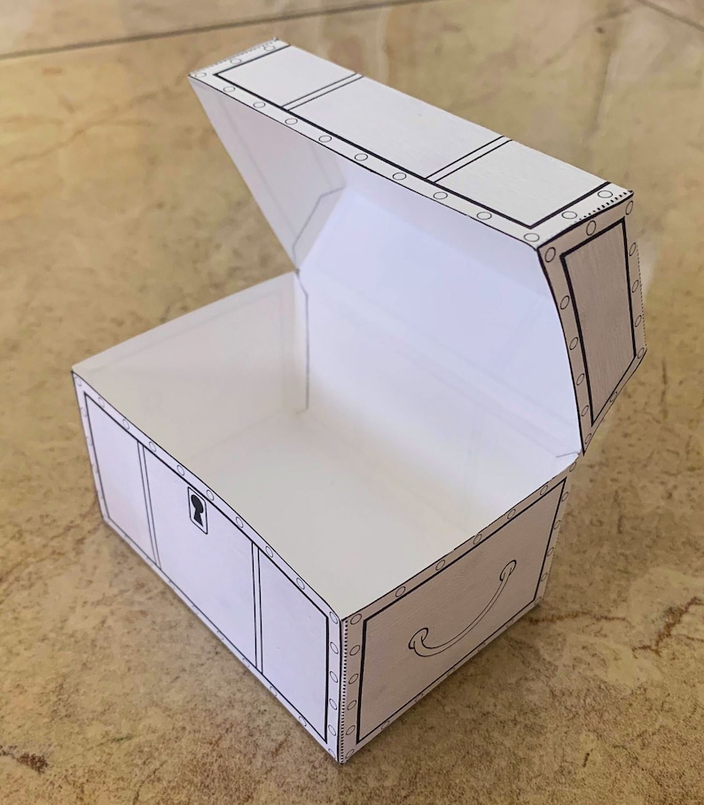 Puede incluir: Un cofre del tesoro de papel blanco con un contorno negro y una cerradura. La tapa est&aacute; abierta y el cofre est&aacute; vac&iacute;o.