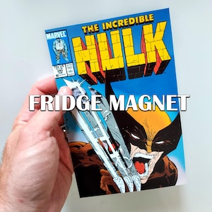 May include: A fridge magnet featuring a comic book cover of "The Incredible Hulk" with Wolverine's claws. The magnet has a blue background with yellow and red lettering. The text "FRIDGE MAGNET" is displayed in white.