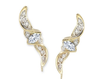 May include: A pair of gold earrings with a curved design and a single marquise-shaped clear stone on each earring.