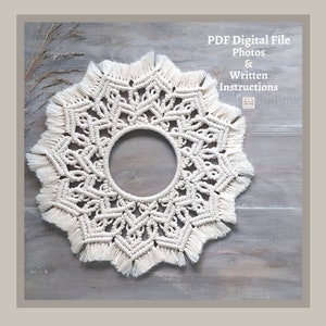 May include: Cream-coloured macrame wall hanging with a circular centre and a starburst design. The fringe adds texture to the piece. The text "PDF Digital File Photos & Written Instructions" is visible.