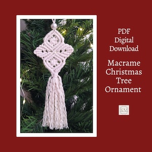 May include: A cream-colored macrame Christmas tree ornament with a tassel, hanging on a green Christmas tree. The ornament has a geometric design and a pearl bead at the top. Text on the right side reads "PDF Digital Download Macrame Christmas Tree Ornament."