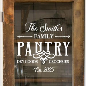 Może przedstawiać: Antyczne drewniane drzwi z szybą, na której znajduje się biała naklejka winylowa z napisem "The Smith's Family Pantry Dry Goods Groceries Est. 2025".