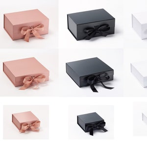 May include: Three sizes of gift boxes with a ribbon and bow. The boxes are available in pink, black, and white.