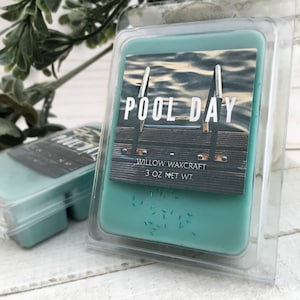 May include: A teal-colored wax melt in a clear plastic container. The label reads "POOL DAY" with an image of a pool and diving board. The product is from Willow Waxcraft and weighs 3 oz.