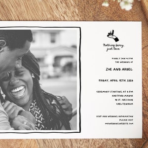 May include: Black and white wedding invitation with a photo of a couple smiling. The invitation reads "Nothing fancy, just love." and includes the couple's names, wedding date, ceremony time, and location.