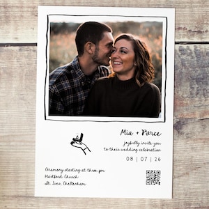 May include: A white wedding invitation with a black border features a photo of a smiling couple. Text includes "Mia + Pierce" and "joyfully invite you to their wedding celebration 08 | 07 | 26". Additional text details the ceremony time and location.