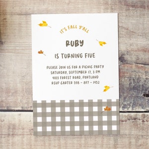 以下が含まれることがあります： 白地に茶色と白の格子模様が施された招待状。カードは秋のテーマで、黄色の葉と「It's Fall Y'all Ruby is Turning Five. Please join us for a picnic party Saturday, September 17, 3 PM 4103 Forest Road, Portland RSVP Carter 598-897-1452」というテキストが書かれている。