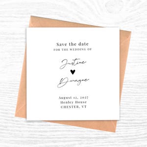 May include: A white save-the-date card with black script and a heart symbol, set inside a brown envelope. The text reads "Save the date for the wedding of Justine & Dwayne, August 12, 2027, Henley House, Chester, VT."