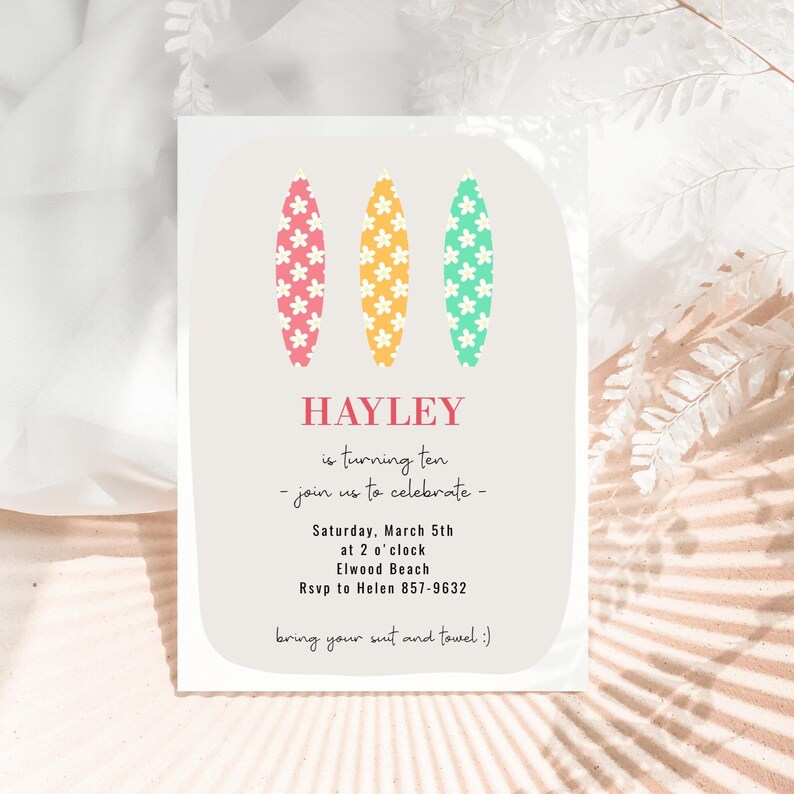 May include: A birthday invitation with a light gray background. The invitation features three colorful surfboards with flower designs. The text reads "HAYLEY is turning ten - join us to celebrate - Saturday, March 5th at 2 o'clock Elwood Beach RSVP to Helen 857-9632 bring your suit and towel :)"