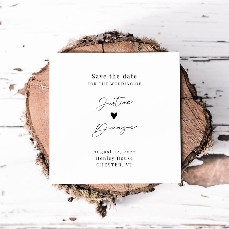 May include: A white square wedding invitation with black text, resting on a wood slice. The text reads "Save the date for the wedding of Justine & Dwayne" with the date August 12, 2027, and the location.