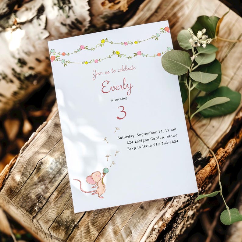 May include: A white invitation card with a floral garland border. The text reads "Join us to celebrate Everly is turning 3. Saturday, September 14, 11 am 524 Lavigne Garden, Stowe Rsvp to Dana 919-782-7834". A cartoon mouse with a pink body and blue eyes holds a dandelion with white seeds.