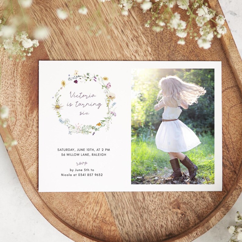 May include: A floral wreath birthday invitation for a girl turning six. The invitation features a watercolor illustration of a wreath of wildflowers and the text "Victoria is turning six". The invitation also includes the date, time, and location of the party, as well as the RSVP information.