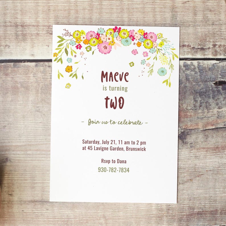 May include: A floral-themed birthday invitation for a girl named Maeve turning two. The invitation features a floral garland with pink, yellow, and green flowers. The text reads "Maeve is turning two. Join us to celebrate - Saturday, July 21, 11 am to 2 pm at 45 Lavigne Garden, Brunswick. Rsvp to Dana 930-782-7834."