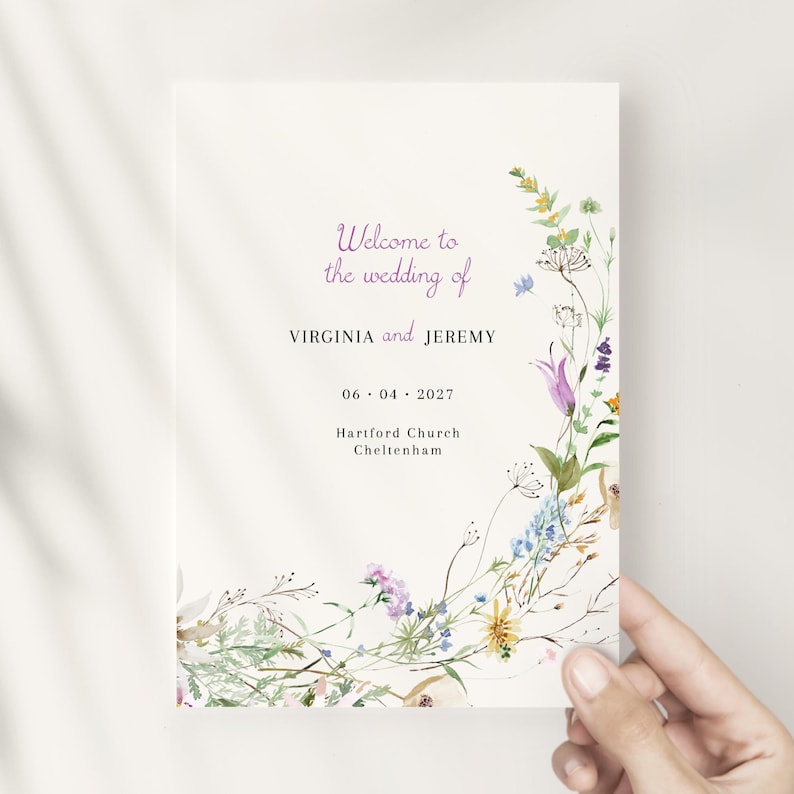 May include: A wedding program with a floral design featuring a variety of flowers in shades of purple, blue, yellow, and pink. The text reads "Welcome to the wedding of VIRGINIA and JEREMY 06.04.2027 Hartiford Church Cheltenham."