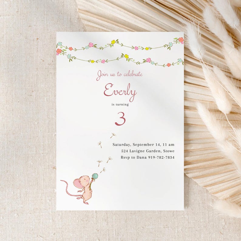 May include: A white birthday invitation with a pink floral garland border. The invitation reads 'Join us to celebrate Everly is turning 3' in pink text. Below the text is a drawing of a mouse holding a dandelion. The invitation also includes the date, time, location, and RSVP information.