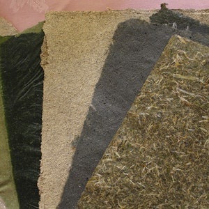 K&ouml;nnte beinhalten: Eine Sammlung handgefertigter Papierb&ouml;gen in verschiedenen Gr&uuml;nt&ouml;nen, Beige und Grau. Die Texturen variieren von glatt bis rau, mit sichtbaren Fasern und Einschl&uuml;ssen. Die Papiere sind f&auml;cherf&ouml;rmig angeordnet und zeigen ihre einzigartigen Eigenschaften.