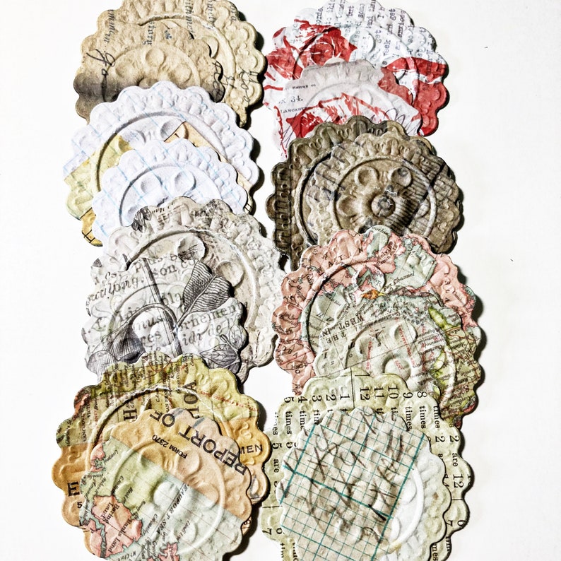May include: A collection of vintage paper ephemera with a variety of designs, including maps, text, and floral patterns. The paper is aged and has a distressed look. The paper is in the shape of circles with scalloped edges.