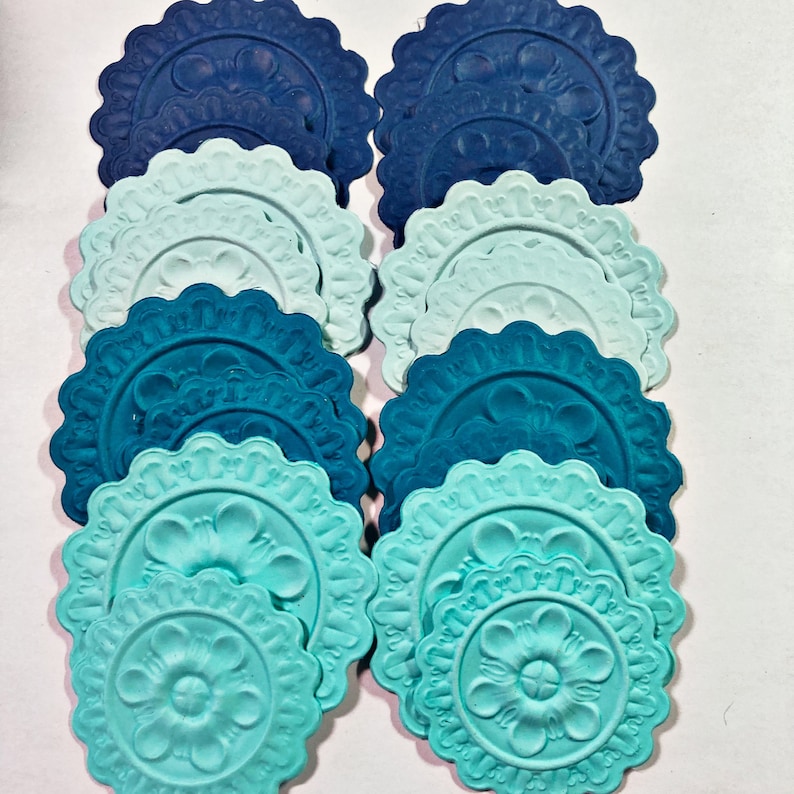 May include: A set of 10 decorative ceiling medallions in shades of blue and teal. The medallions are made of a lightweight material and have a scalloped edge. They are perfect for adding a touch of elegance to any room.