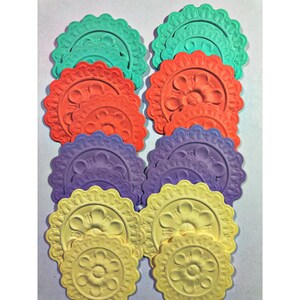 May include: A set of 10 decorative ceiling medallions in various colors, including teal, orange, purple, and yellow. Each medallion features a raised, floral design.