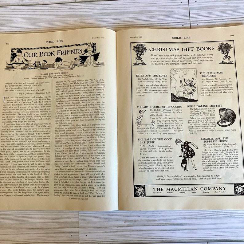 Peut inclure: Une couverture de livre vintage repr&eacute;sentant un renne noir et blanc avec un nez rouge. Le titre du livre est "The Christmas Reindeer" et l'auteur est "Thornton W. Burgess".