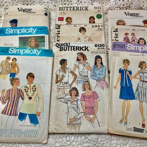 May include: A collection of vintage sewing patterns for women's tops and dresses. The patterns are from Simplicity, Butterick, and Vogue. The patterns feature different styles, including a striped top, a floral print top, and a solid color dress.
