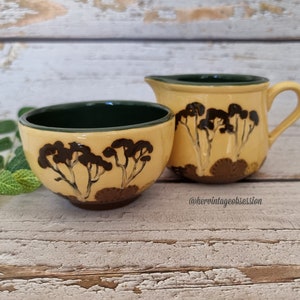 Puede incluir: Un juego de dos boles de cerámica vintage para azúcar y crema, con un glaseado amarillo y diseños de árboles marrones. Los boles tienen un borde verde.