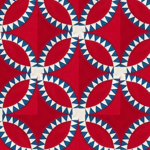 Op de afbeelding: Een rode quilt met een patroon van witte en blauwe cirkels. De cirkels zijn gerangschikt in een herhalend patroon, waardoor een geometrisch ontwerp ontstaat.