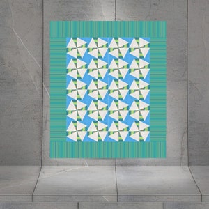 Op de afbeelding: Een blauw en wit geometrisch patroon quilt met een groene rand. Het patroon is gemaakt van herhalende driehoeken.
