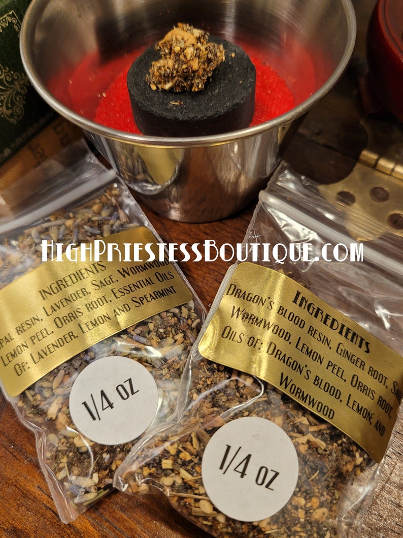 May include: Two small clear plastic bags filled with dried herbs and labeled with gold text. The bags are labeled "Ingredients" and list the ingredients for each blend. The bags are labeled with a white circle that says "1/4 oz".