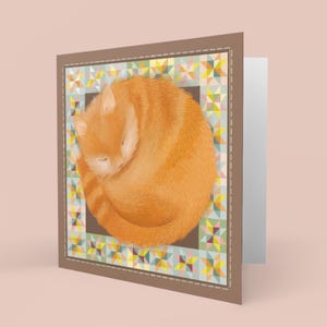 May include: A greeting card featuring a curled up orange cat sleeping on a colourful patchwork quilt.