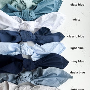 Pu&ograve; includere: Nove campioni di tessuto annodati in un nodo, disposti verticalmente dall'alto verso il basso. I campioni sono dei seguenti colori: salvia polverosa, blu ardesia, bianco, blu classico, blu chiaro, blu navy, blu polvere e grigio chiaro.