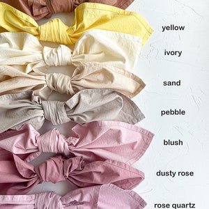 Pu&ograve; includere: Nove campioni di tessuto legati a fiocco, disposti verticalmente dall'alto verso il basso. I campioni sono terracotta, giallo, avorio, sabbia, ghiaia, blush, rosa polveroso e quarzo rosa.