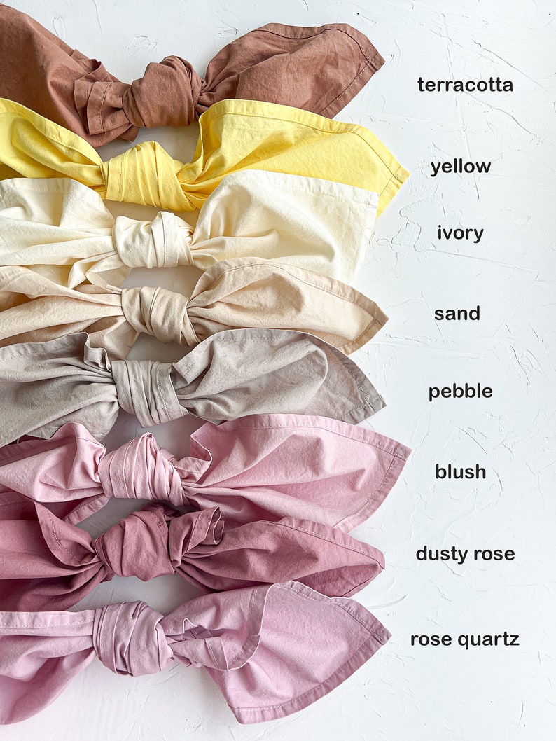 Pu&ograve; includere: Nove campioni di tessuto legati a fiocco, disposti verticalmente dall'alto verso il basso. I campioni sono terracotta, giallo, avorio, sabbia, ghiaia, blush, rosa polveroso e quarzo rosa.