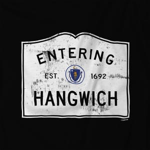 May include: A black t-shirt featuring a white, distressed-style rectangular sign graphic with black text that reads ENTERING HANGWICH EST. 1692. In the center is a circular emblem containing the blue and gold Massachusetts state seal.
