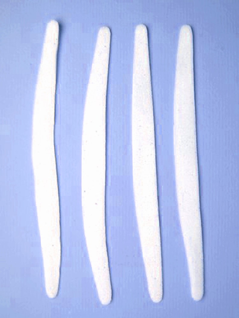 May include: Four white, curved, decorative pieces on a light blue background.