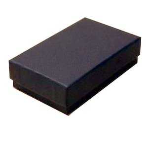 Puede incluir: Una caja de cartón negra con una superficie texturizada.