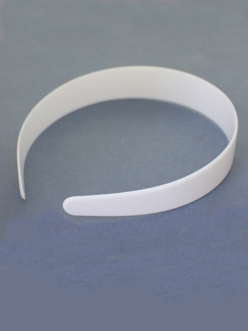 May include: A white plastic headband. The headband is smooth and has a simple design.