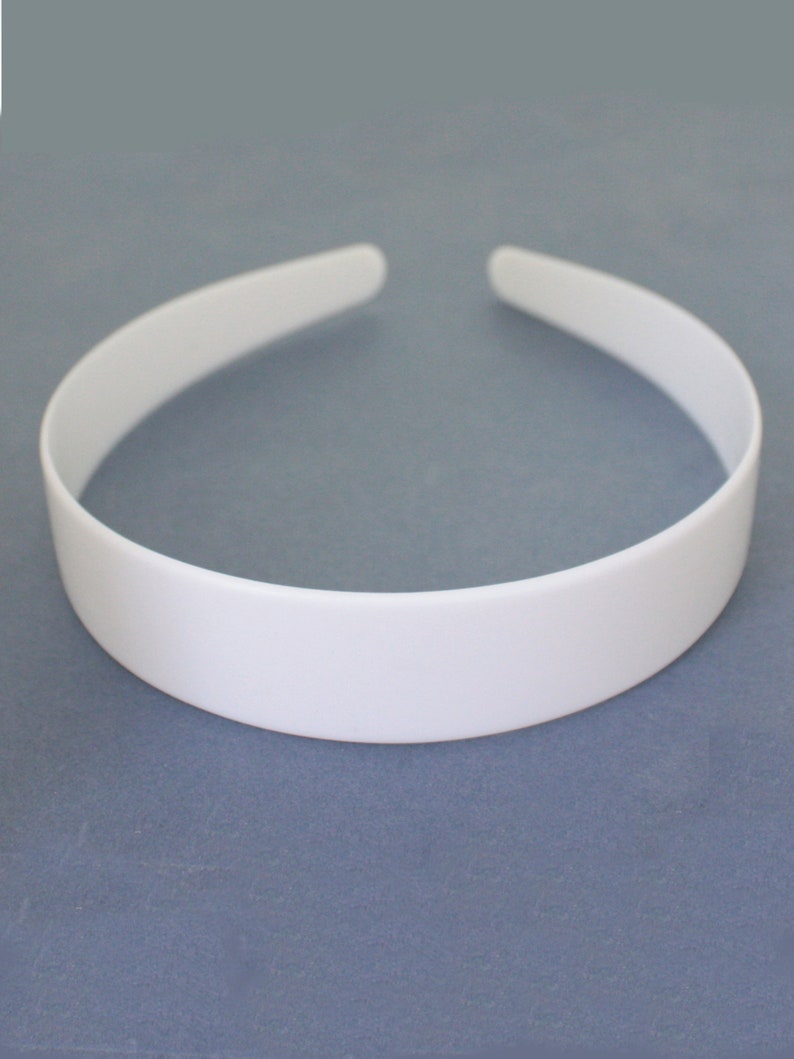 May include: A white plastic headband. The headband is smooth and has a simple design.