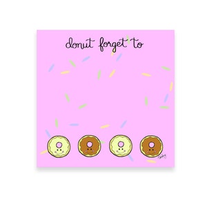 May include: Pink notepad with the text "donut forget to" written in black cursive. The notepad has a light pink background with a pattern of colorful sprinkles. There are three cartoon donuts at the bottom of the notepad with happy faces.