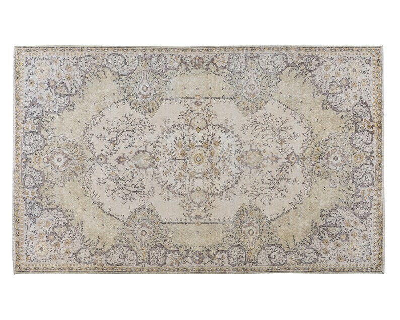 May include: Rectangular area rug with an intricate, faded floral pattern in cream, beige, and gray tones. The rug features a central medallion design and a border with stylized floral motifs, creating a vintage aesthetic.