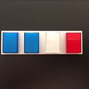 May include: A white panel with four rectangular buttons. The buttons are blue, blue, white, and red.