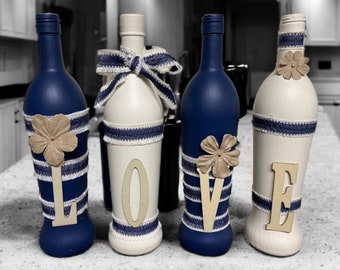 Navy blue and cream decorated wine bottles. Wording “Love”