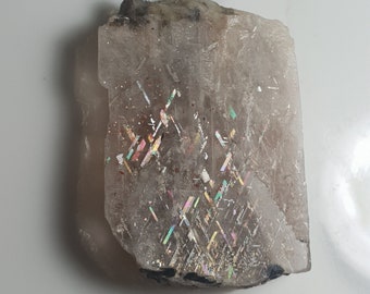 May include: A clear, iridescent sunstone with a rough, natural shape. The stone displays a rainbow of colors, including red, orange, yellow, green, blue, and purple.
