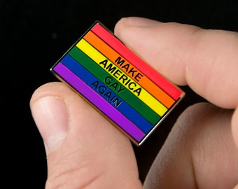 Könnte beinhalten: Eine Regenbogen-Emaille-Anstecknadel mit dem Text "Make America Gay Again".