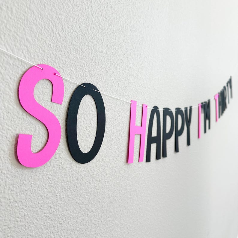 May include: Pink and black paper banner with the text "SO HAPPY I'M THIRTY".