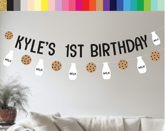 May include: Black and white banner with the text "KYLE'S 1ST BIRTHDAY" and milk bottle and cookie illustrations.