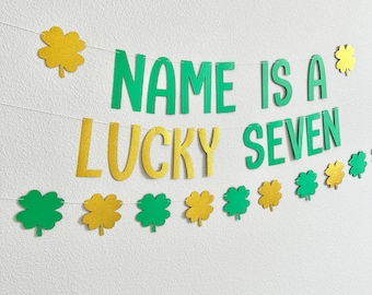 May include: Green and gold glitter banner with the text "NAME IS A LUCKY SEVEN". The banner is decorated with shamrock cutouts.